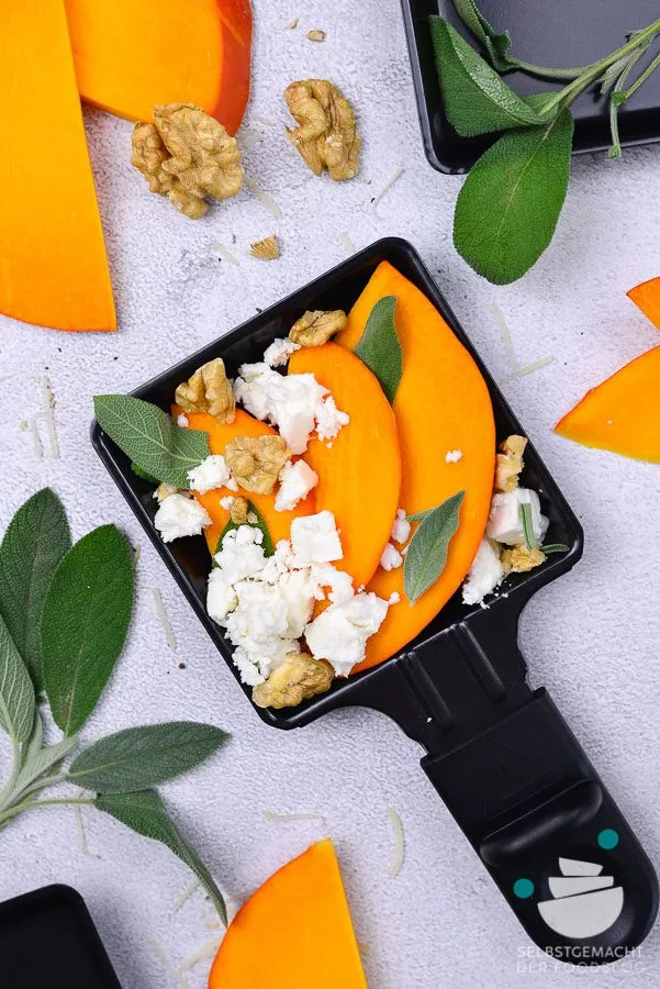 Kürbisscheiben mit Ziegenkäse und frischem Salbei im Raclette Pfännchen, eine herbstliche und aromatische vegetarische Raclette Kombination.