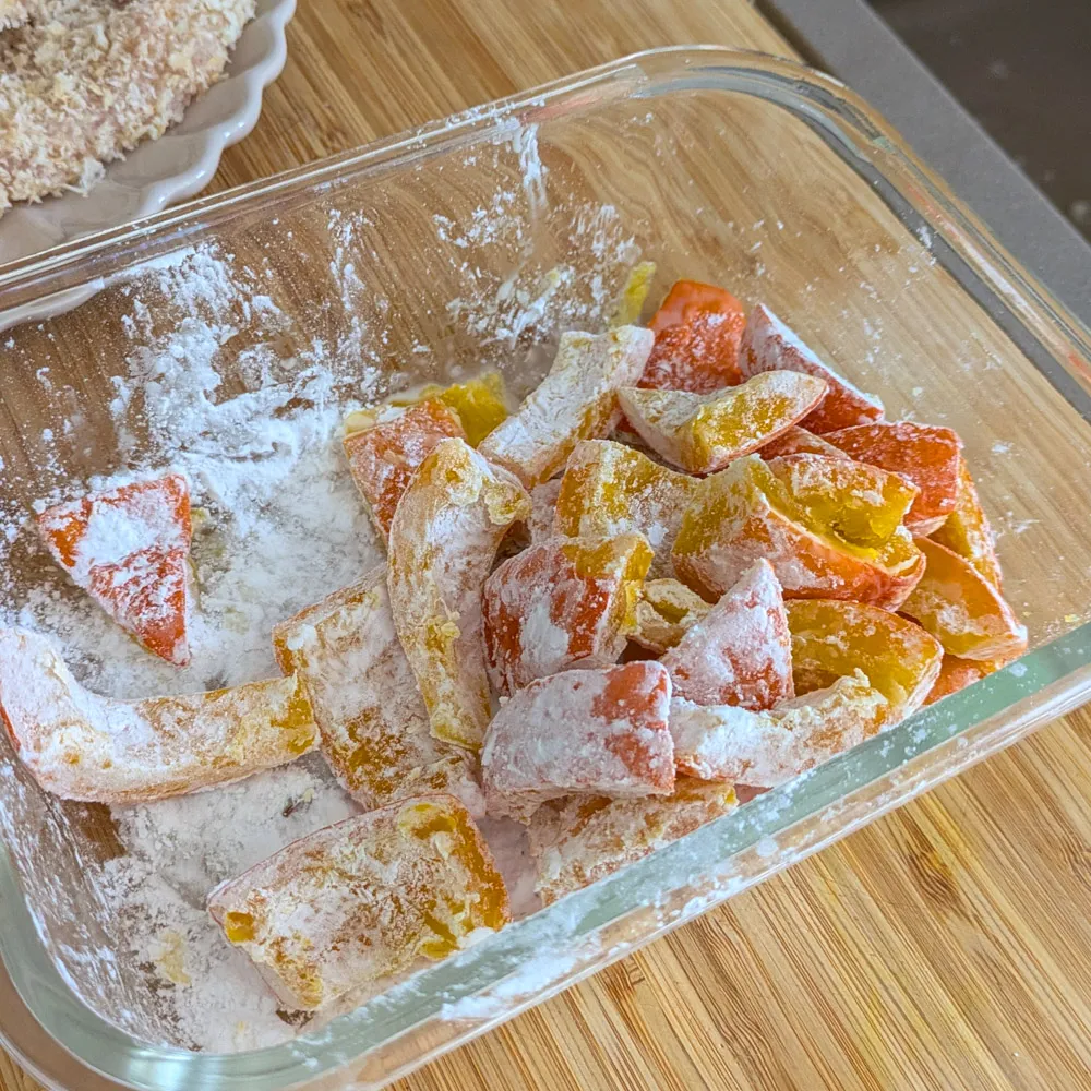 Kürbisstücke mit japanischer Kartoffelstärke (Katakuriko) bestäubt, bereit zum Anbraten.