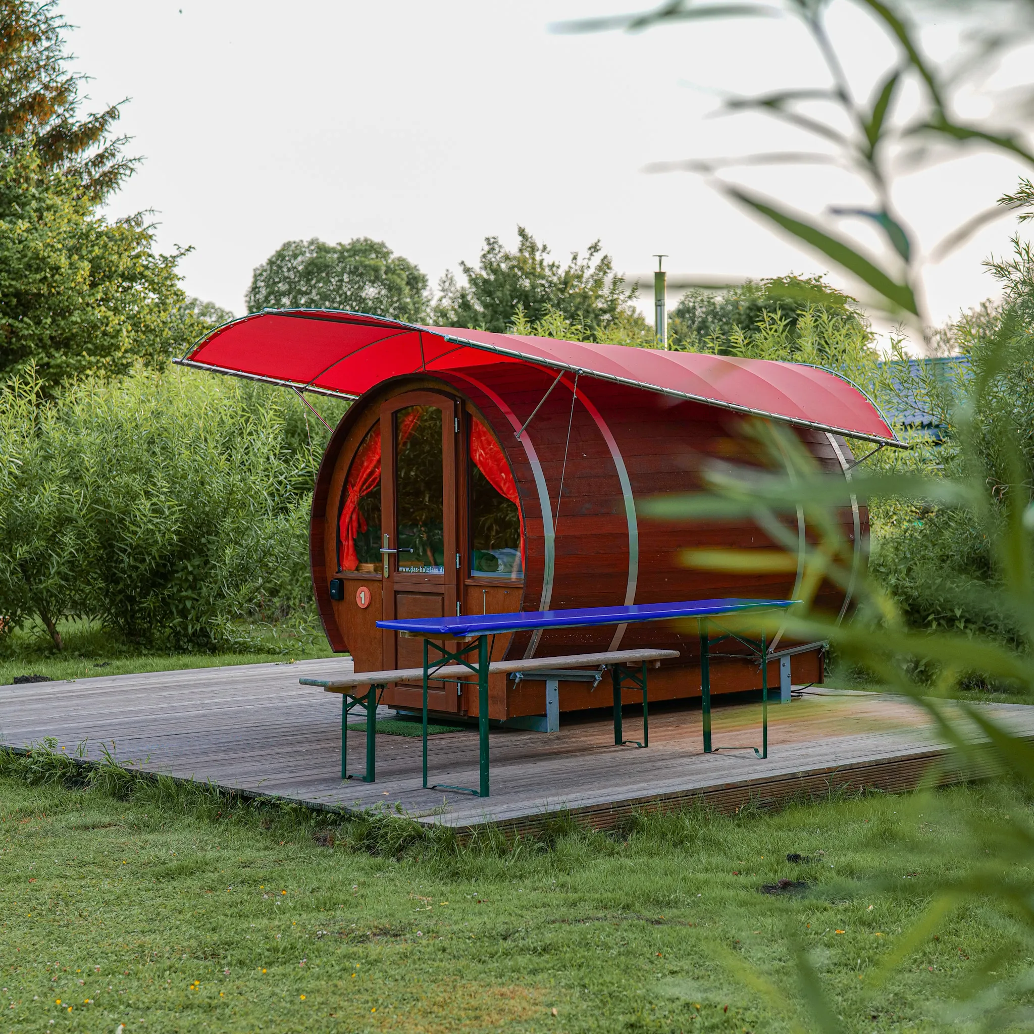 Kuscheliges Interieur des Camping-Fasses mit Betten und Nachttischlampe