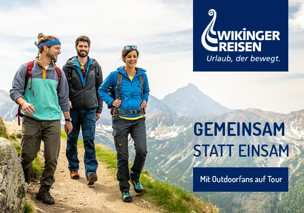 Lachende junge Frau im Gespräch mit ihrem Reisepartner, symbolisiert fröhliche Single- und Alleinreisen