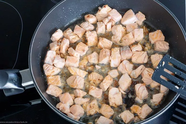 Lachswürfel werden in der Pfanne goldbraun angebraten, für mehr Röstaromen bei Tagliatelle mit Lachs