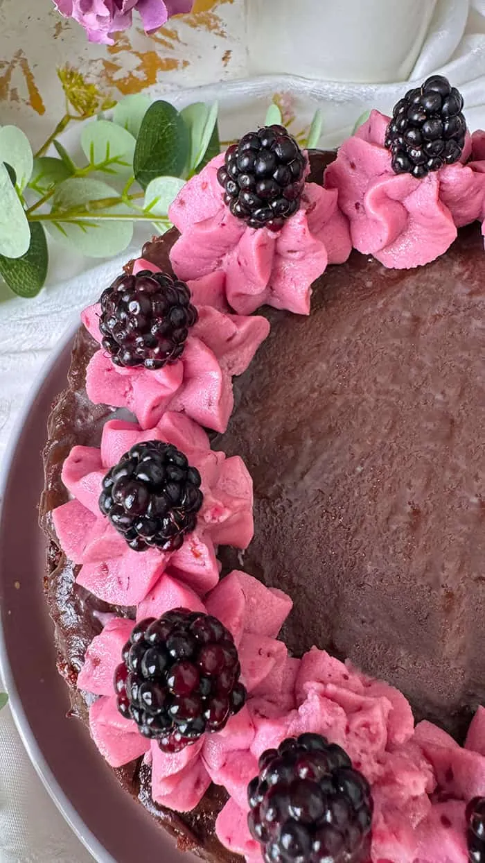 Leckere Brombeer Sahne Torte von oben, reich verziert mit frischen Brombeeren und Sahnetupfen