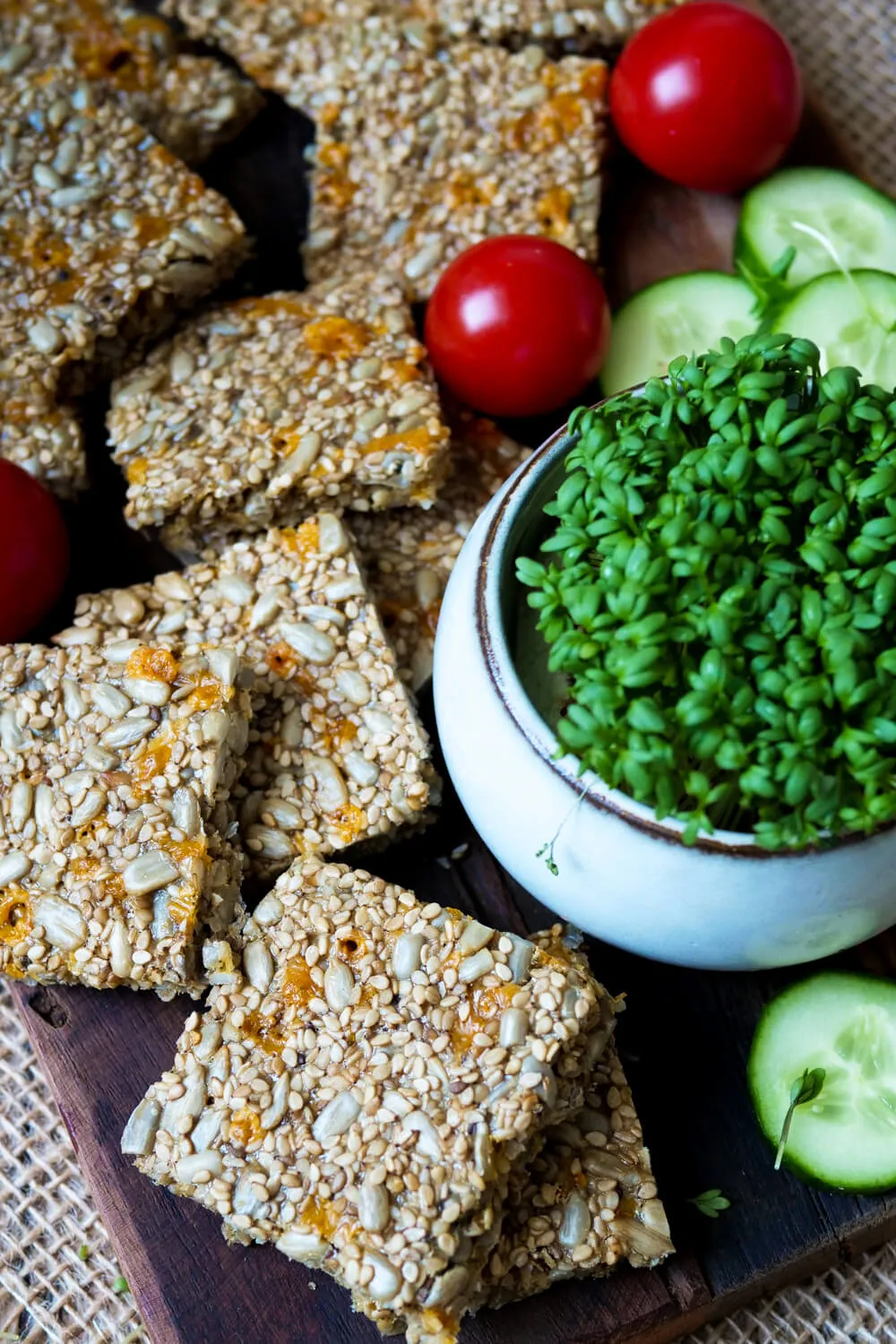 Low Carb Cracker mit Tomaten und Gurken auf dem Holzbrett