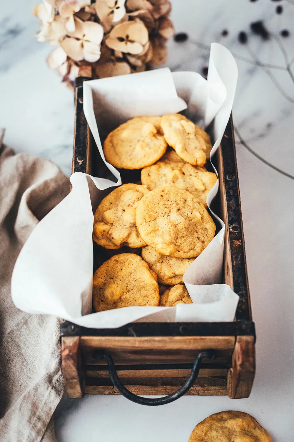 Macadamia-Cookies mit weißen Schokoladenstückchen, perfekt gebacken und leicht gebräunt. Ein einfaches Rezept für köstliche Weihnachtskekse.