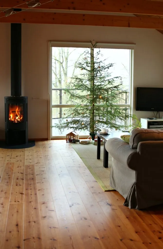 Mädchen vor einem Weihnachtsbaum, der mit selbstgemachtem Schmuck verziert ist