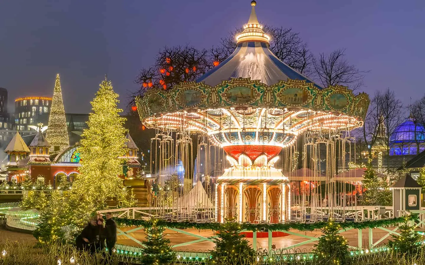 Magische Weihnachtsbeleuchtung und ein Karussell im Tivoli Gardens, Kopenhagen, Dänemark, ein charmantes Reiseziel.