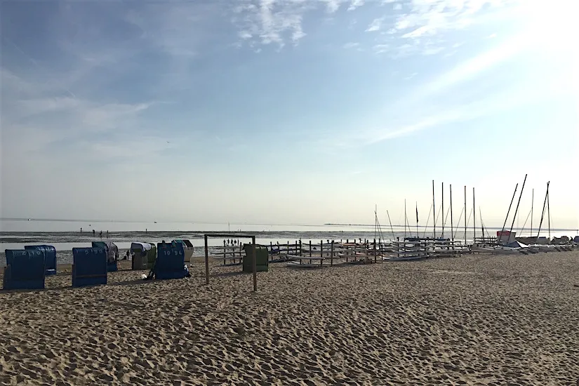 Malerischer Strand auf Föhr mit Wassersportlern, Symbol für vielfältigen Aktivurlaub Norddeutschland