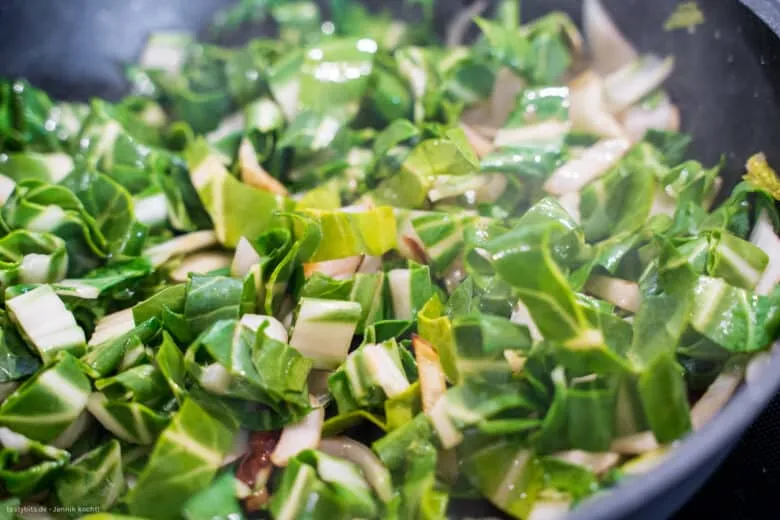 Mangoldblätter und -stiele garen zusammen in der Pfanne, abgelöscht mit Weißwein.