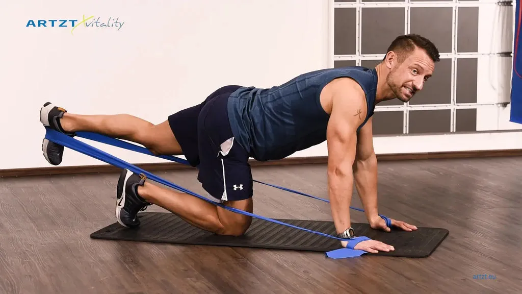 Mann vollführt die Übung Leg Extension Balance mit einem TheraBand.