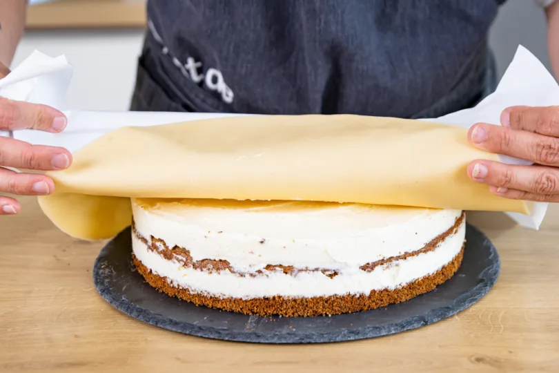 Marzipandecke vorsichtig auf die Torte legen