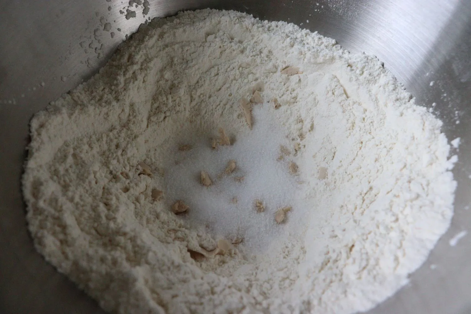 Mehl mit Salz gemischt, Hefe und Zucker in der Mitte für Hefeteig.