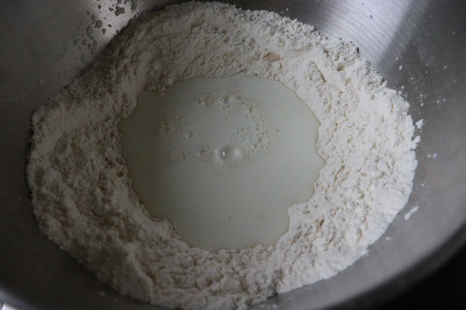 Mehl mit Salz gemischt, Hefe, Zucker und Milch in der Mitte für Hefeteig.