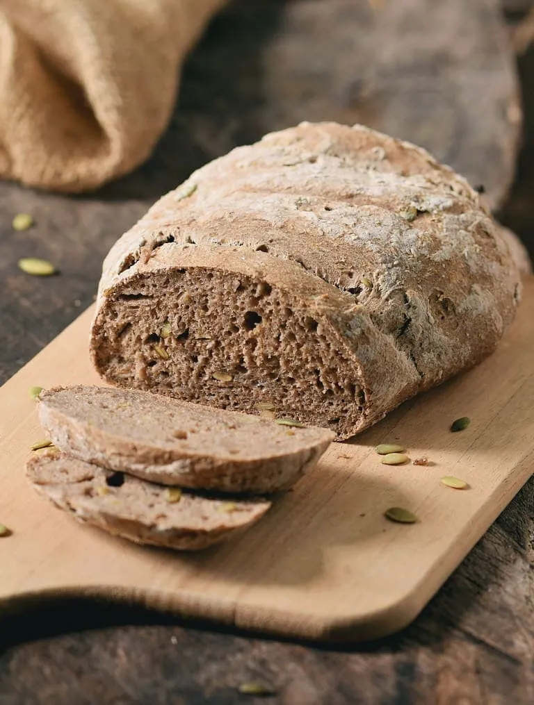 Mehrere Scheiben eines hausgemachten, glutenfreien und eifreien Brotes, aufgereiht und bereit zum Verzehr