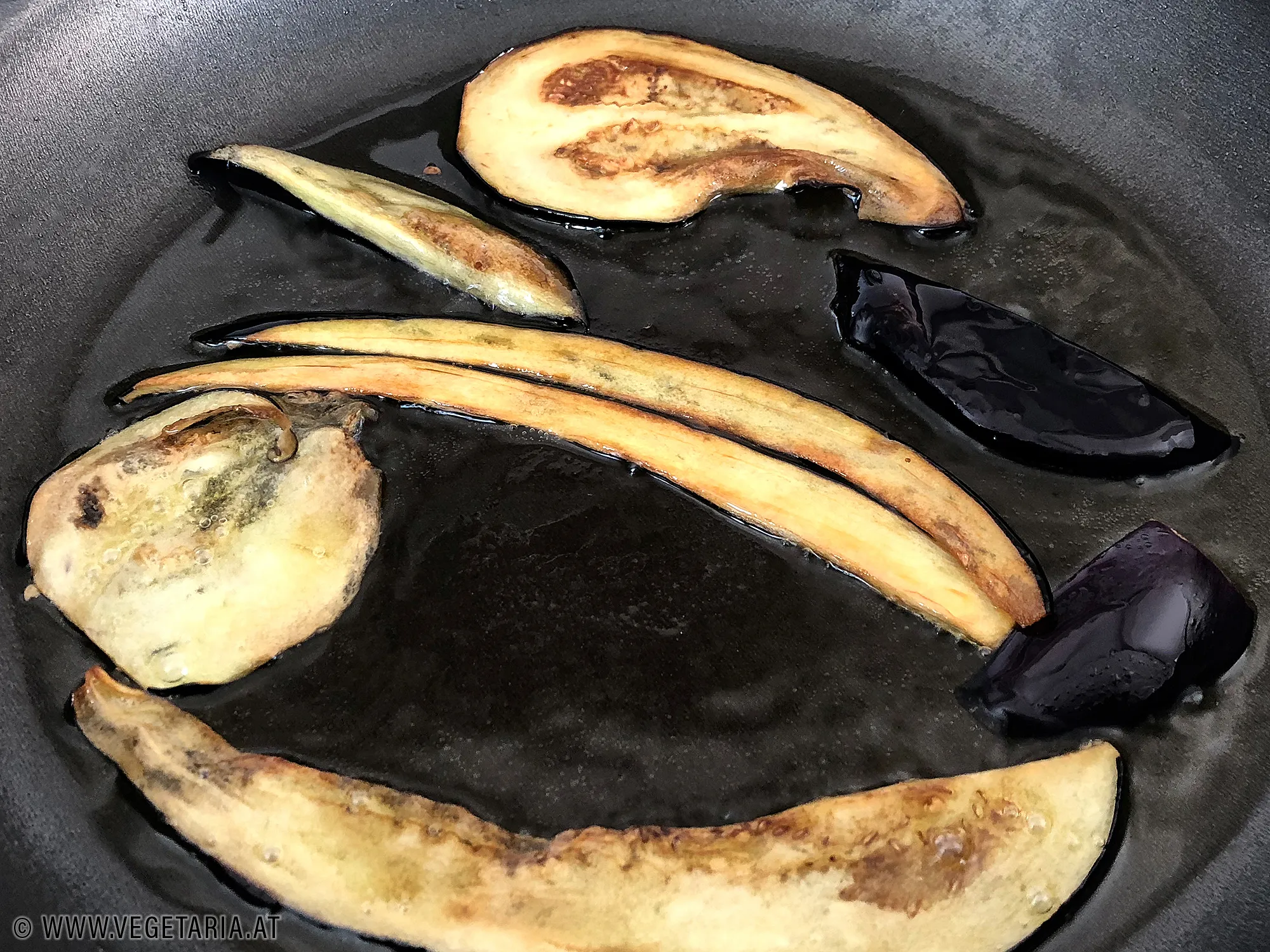 Melanzanischeiben werden in heißem Olivenöl goldbraun gebraten.