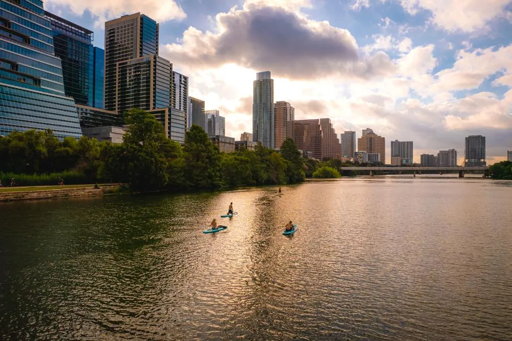 Menschen stehen beim Stand-Up-Paddling auf dem Lady Bird Lake.