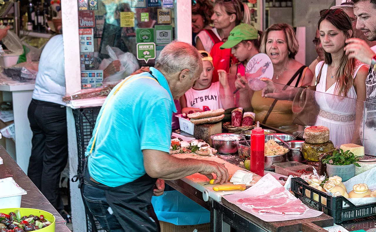 Menschenansammlung vor einem Stand auf dem Markt in Syrakus