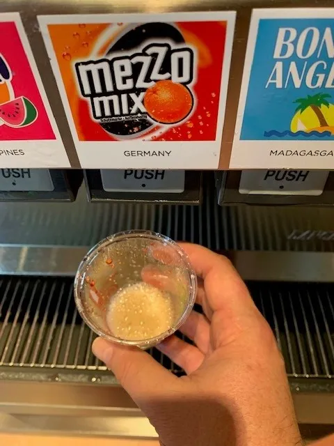 Mezzo Mix Flasche in der Hand: Die Freude am Wiederentdecken des deutschen Favoriten auf Orangengeschmack, erhältlich auch als Mezzo Mix Zero.