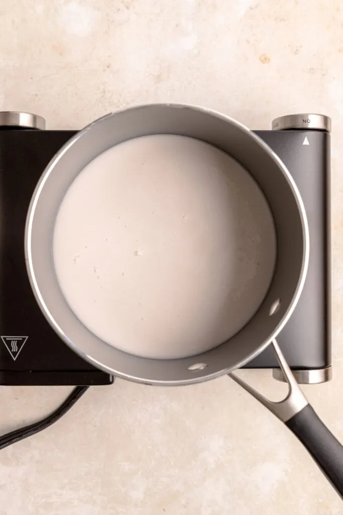 Milch wird in einem Topf zum Kochen gebracht, ein wichtiger erster Schritt für cremigen Grießbrei.