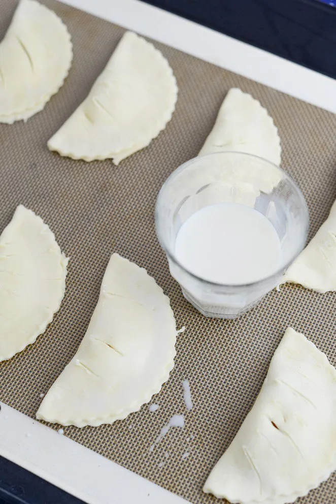 Mirabellentaschen mit Milch bestrichen und bereit zum Backen
