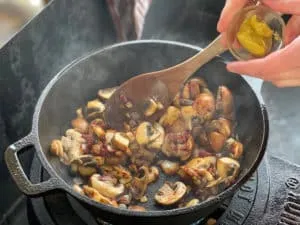 Mischung aus mittelscharfem Senf, Zwiebeln und Champignons in der Pfanne