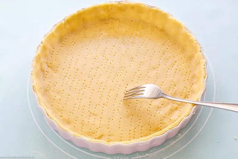 Mit Gabel eingestochener Quiche Teig vor dem Blindbacken, damit Luft entweicht.