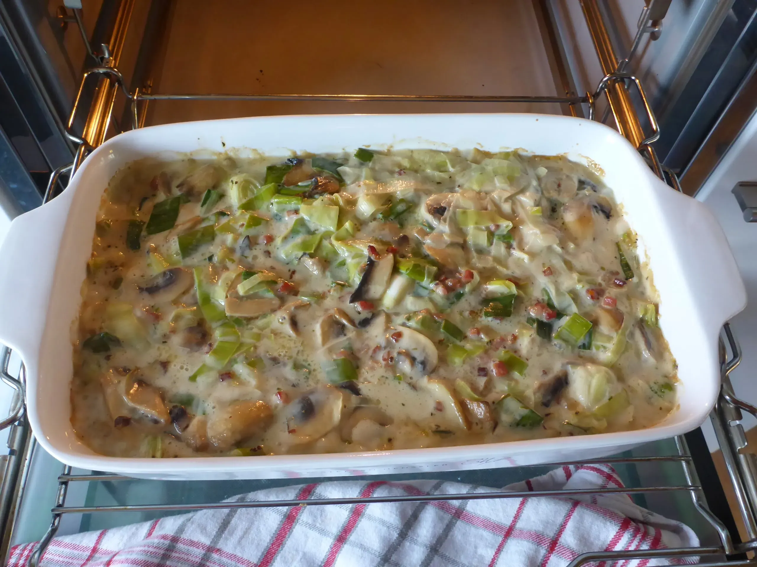 Nach 60 Minuten im Ofen wird die Folie von der Schnitzelpfanne entfernt, um die goldbraune Oberfläche der Sauce und des Fleisches zu ermöglichen.