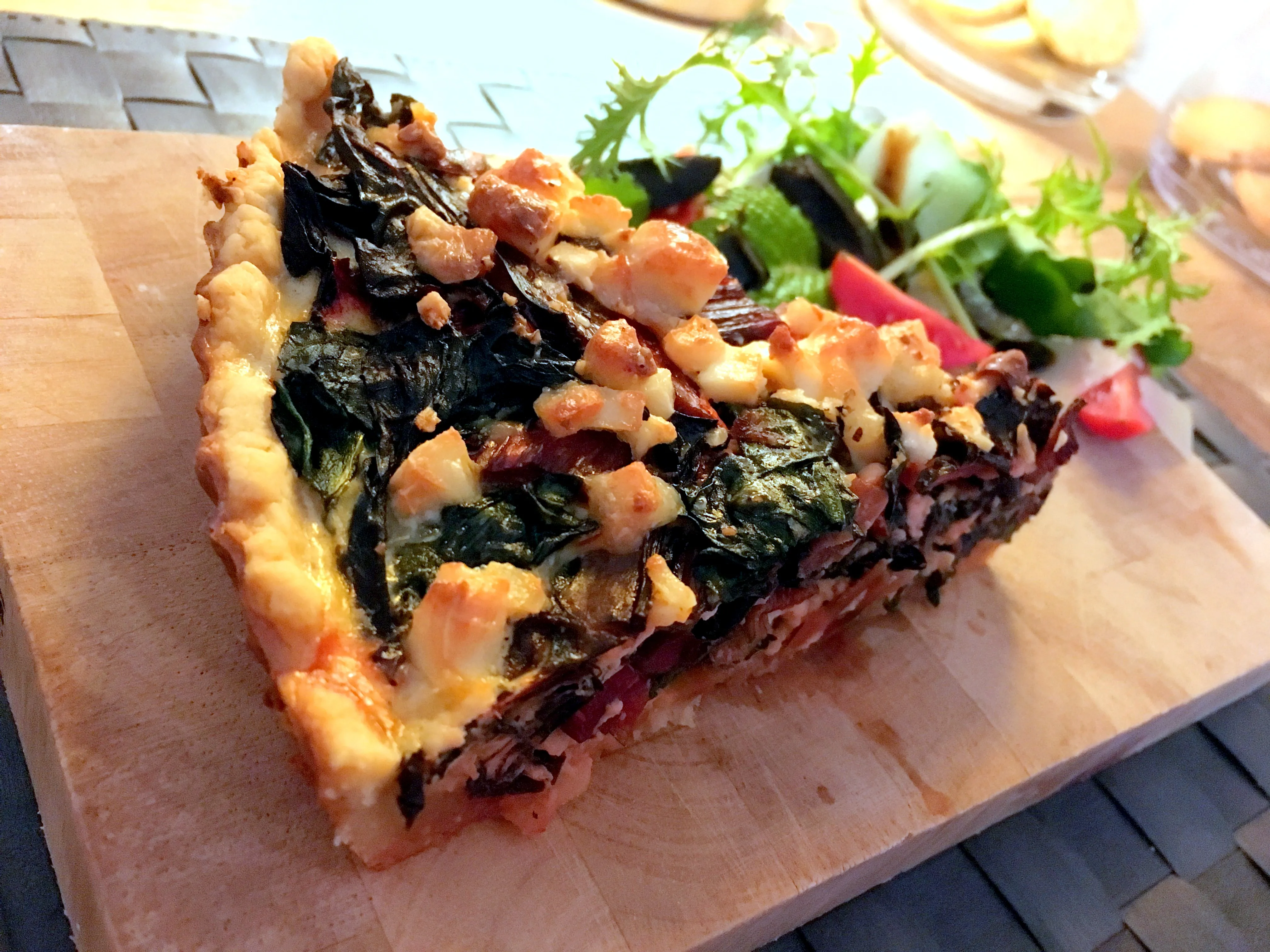 Nahaufnahme der herzhaften Füllung einer frisch gebackenen Mangold-Quiche