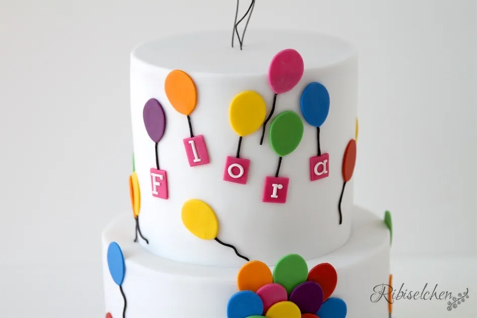 Nahaufnahme der liebevoll geformten Fondant-Luftballons, die die Seite des Geburtstagskuchens schmücken