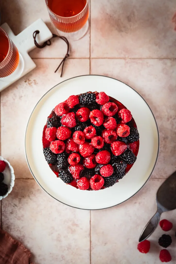 Nahaufnahme der Mascarpone Joghurt Sahne Torte mit glänzendem Tortenguss und bunten Beeren