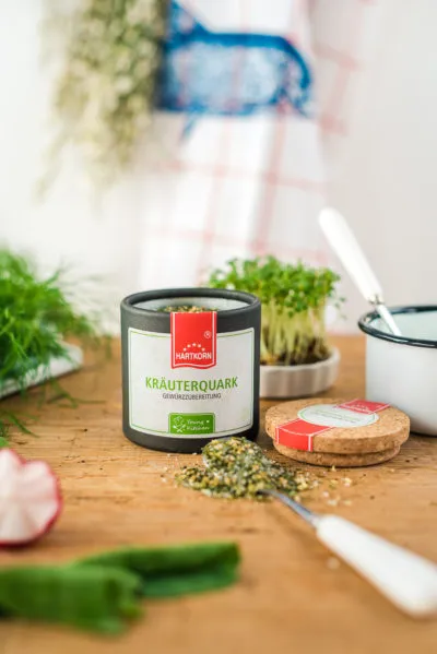 Nahaufnahme einer aufgeschnittenen Ofenkartoffel mit reichlich Krabben, Dill und rosa Radieschenscheiben.