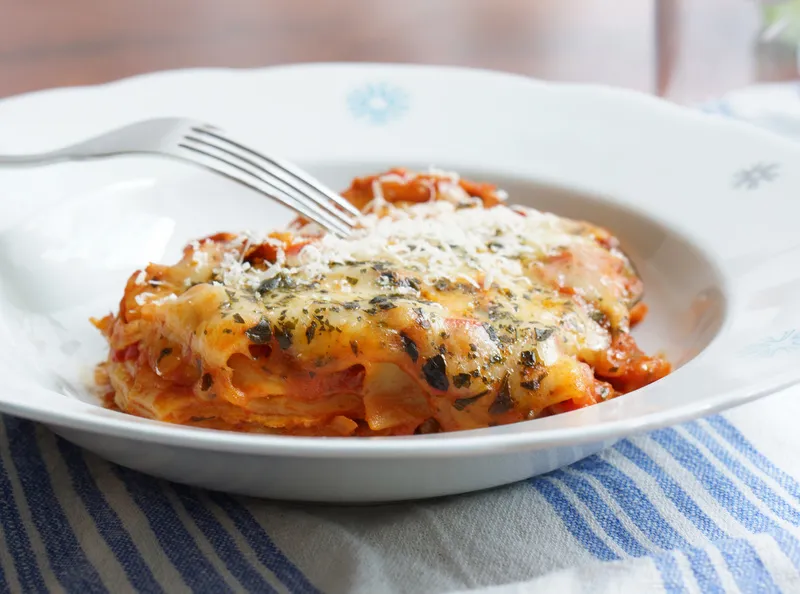 Nahaufnahme einer cremigen One-Pot Lasagne vegetarisch mit Mozzarella und Basilikum