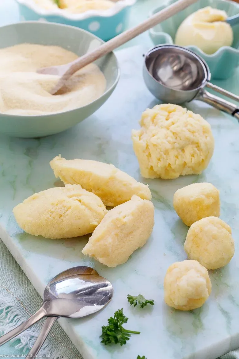 Nahaufnahme einer fluffigen Grießnocke in klarer Suppenbrühe, typisch für Omas Grießklößchensuppe.