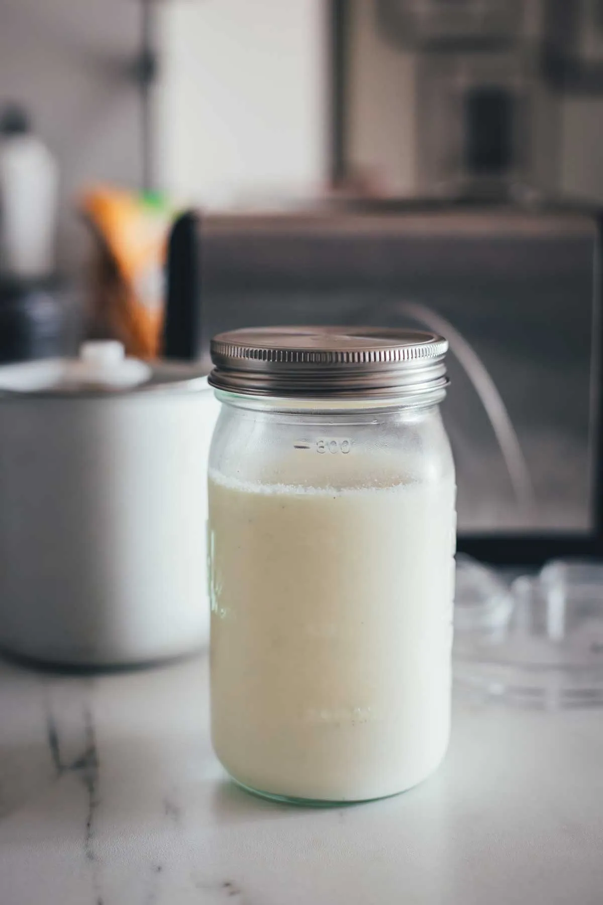 Nahaufnahme einer glatten Vanilleeismasse in einem Topf, die Vorbereitung für das cremigste Vanilleeis.
