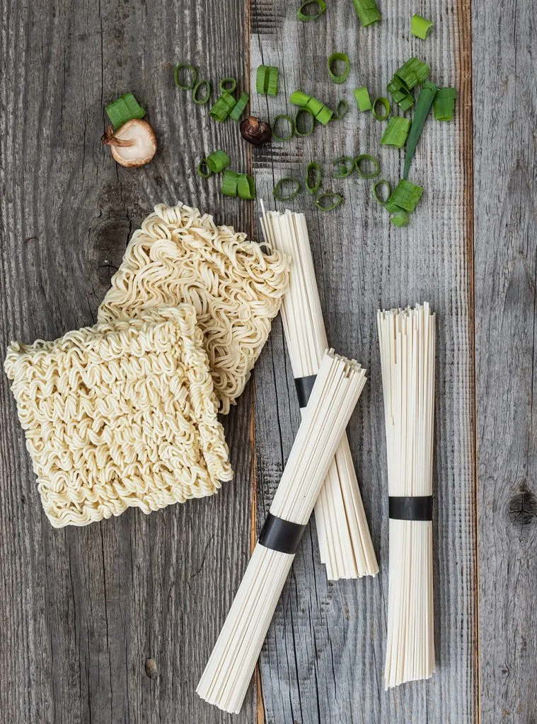 Nahaufnahme einer hausgemachten Instant Ramen Suppe mit weichem Ei, Pilzen und Nudeln, die das Umami hervorhebt.