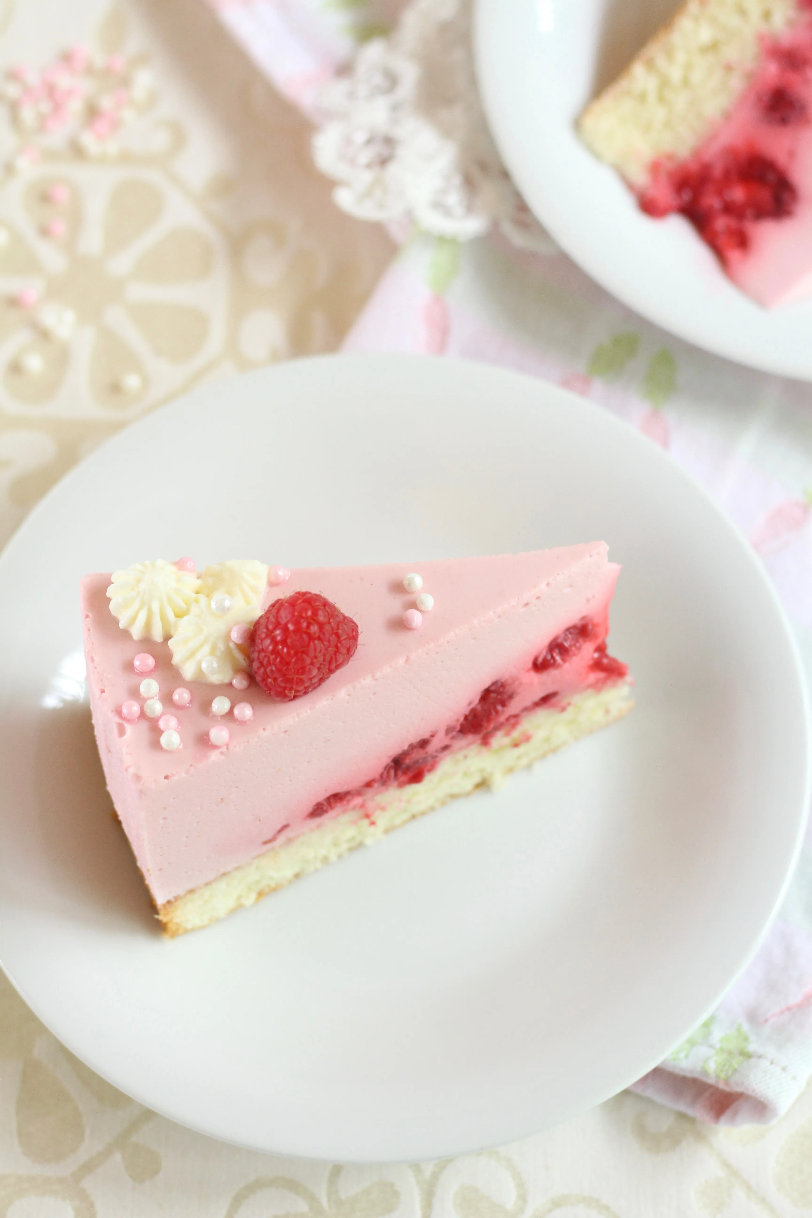 Nahaufnahme einer Himbeersahne-Torte von oben mit Details der Dekoration