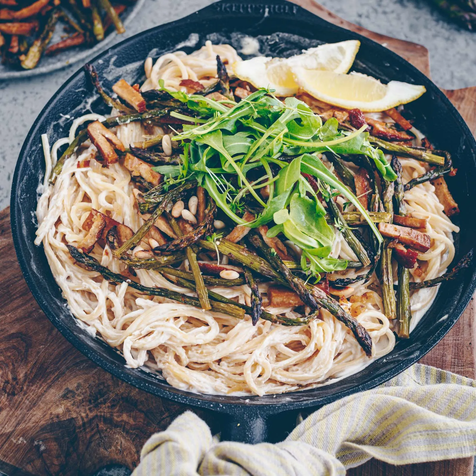 Nahaufnahme einer Portion cremiger Spargel-Pasta mit Tofu auf einem Teller