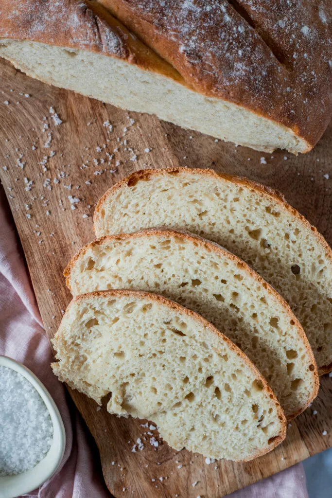 Nahaufnahme einer Scheibe frisch gebackenen Brotes mit einer Butterblume darauf.