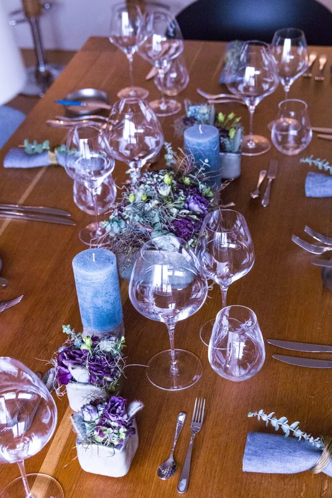 Nahaufnahme einer stilvollen Tischdekoration mit Blumenarrangement und Geschirr beim perfekten Dinner