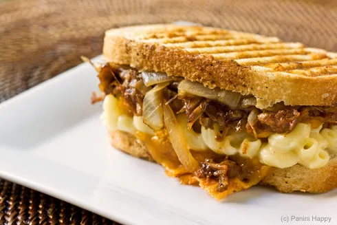 Nahaufnahme eines aufgeschnittenen Grilled Mac & Cheese Paninis mit BBQ Pulled Pork, Käse und Nudeln