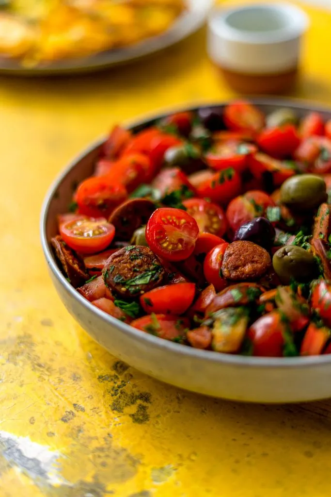Nahaufnahme eines frischen Chorizo-Tomaten-Salats, der die lebendigen Farben und Texturen der Zutaten hervorhebt.