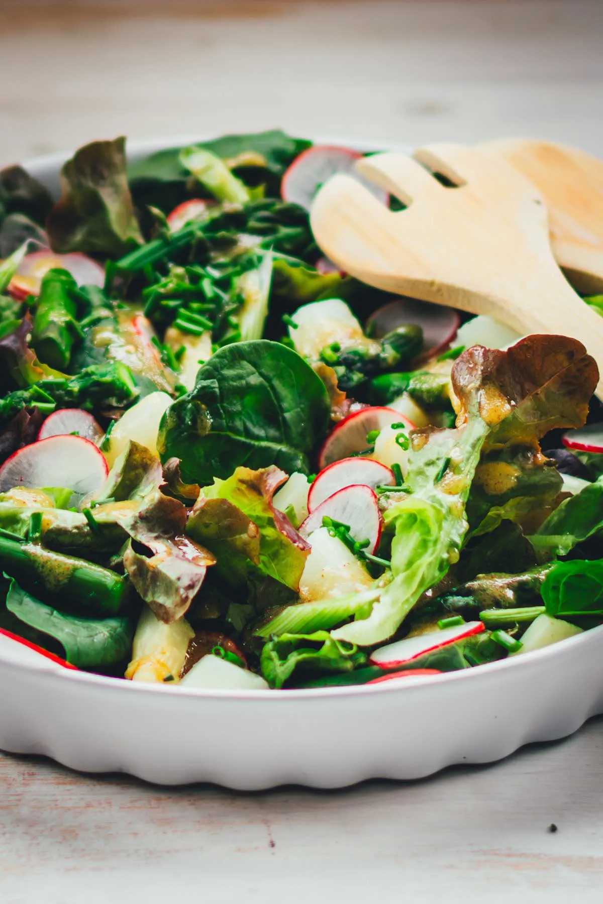 Nahaufnahme eines knackigen Frühlingssalats mit grünen Blättern und Radieschenscheiben