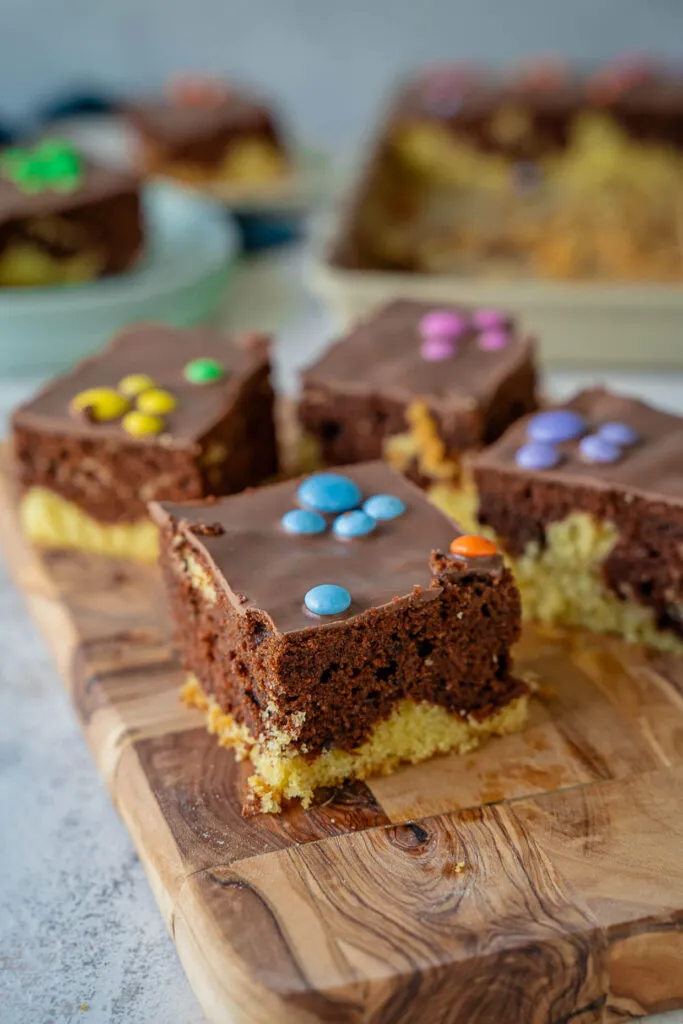 Nahaufnahme eines saftigen Marmorkuchenstücks mit bunten Smarties-Pfoten, ideal für einen Paw Patrol Kindergeburtstag.