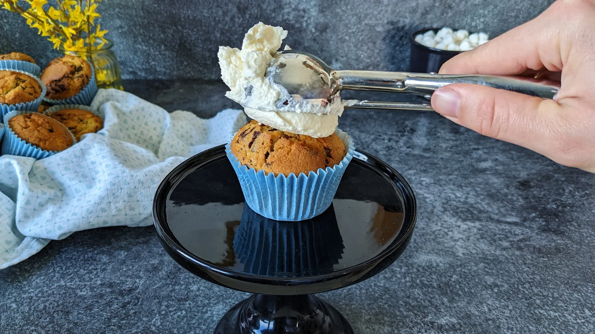 Nahaufnahme eines Schaf-Muffins mit Marshmallow-Wolken und Marzipan-Gesicht