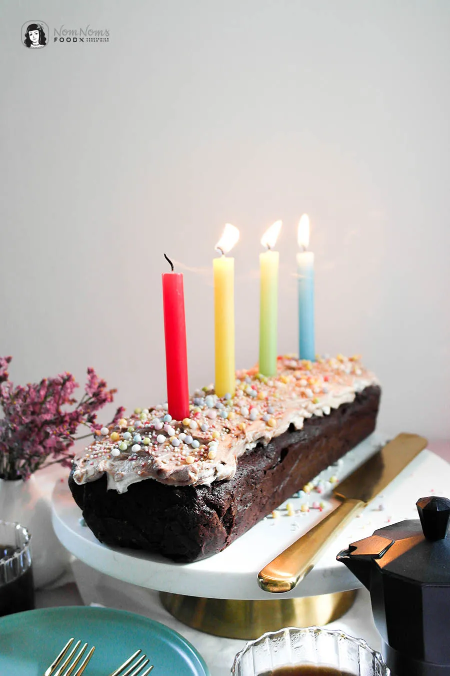 Nahaufnahme eines Stücks Brownie-Geburtstagskuchen für Dreijährige, reich verziert mit bunten Streuseln