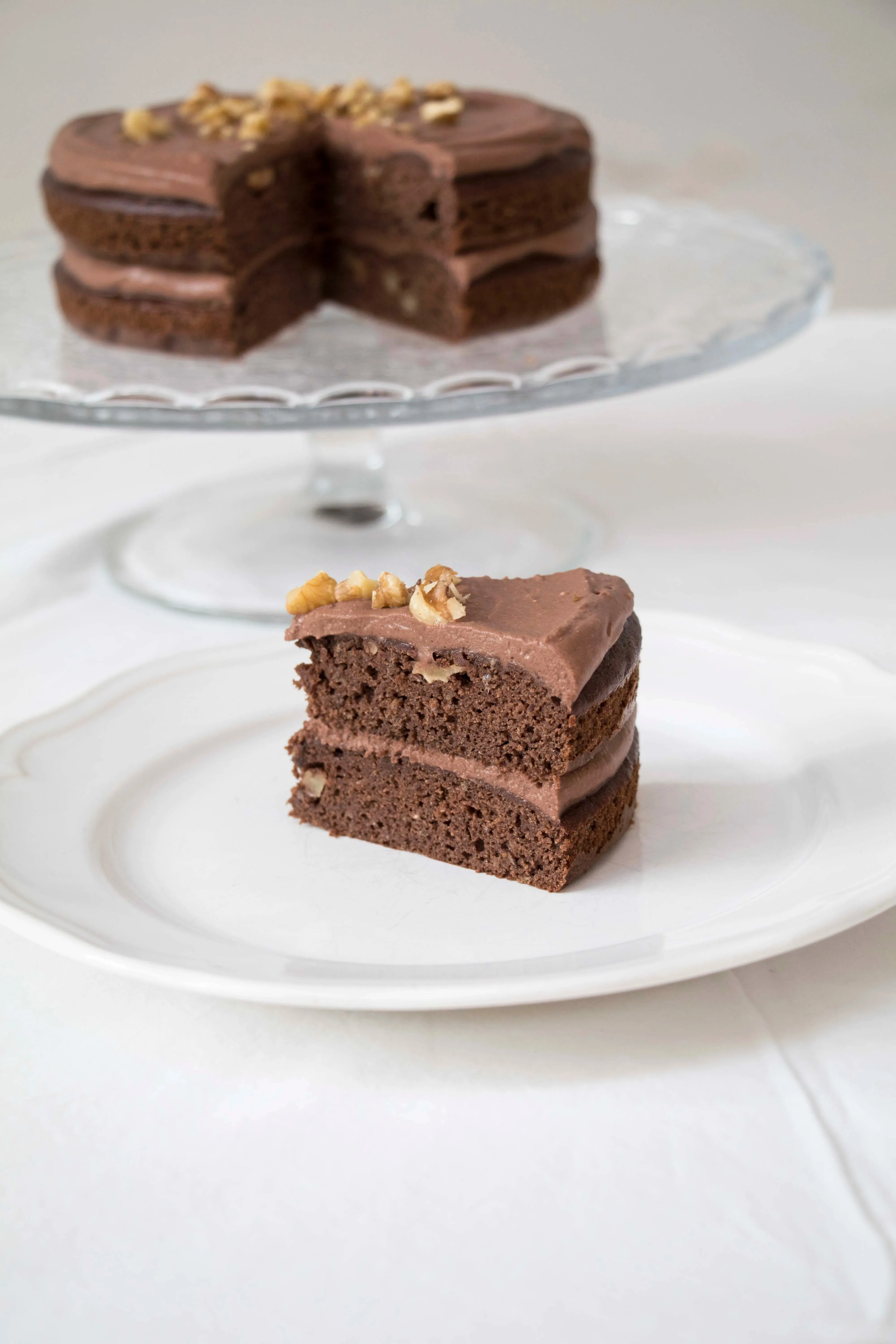 Nahaufnahme eines Stücks zuckerfreier Schokokuchen mit cremiger Glasur, bereit zum Verzehr.