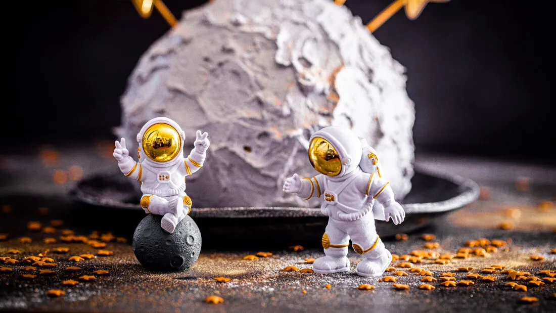 Nahaufnahme von Astronautenfiguren auf einer Mondtorte