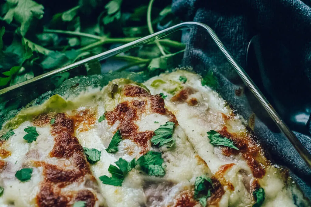 Nahaufnahme von Chicoree-Schinken-Röllchen, bereit für den Backofen.
