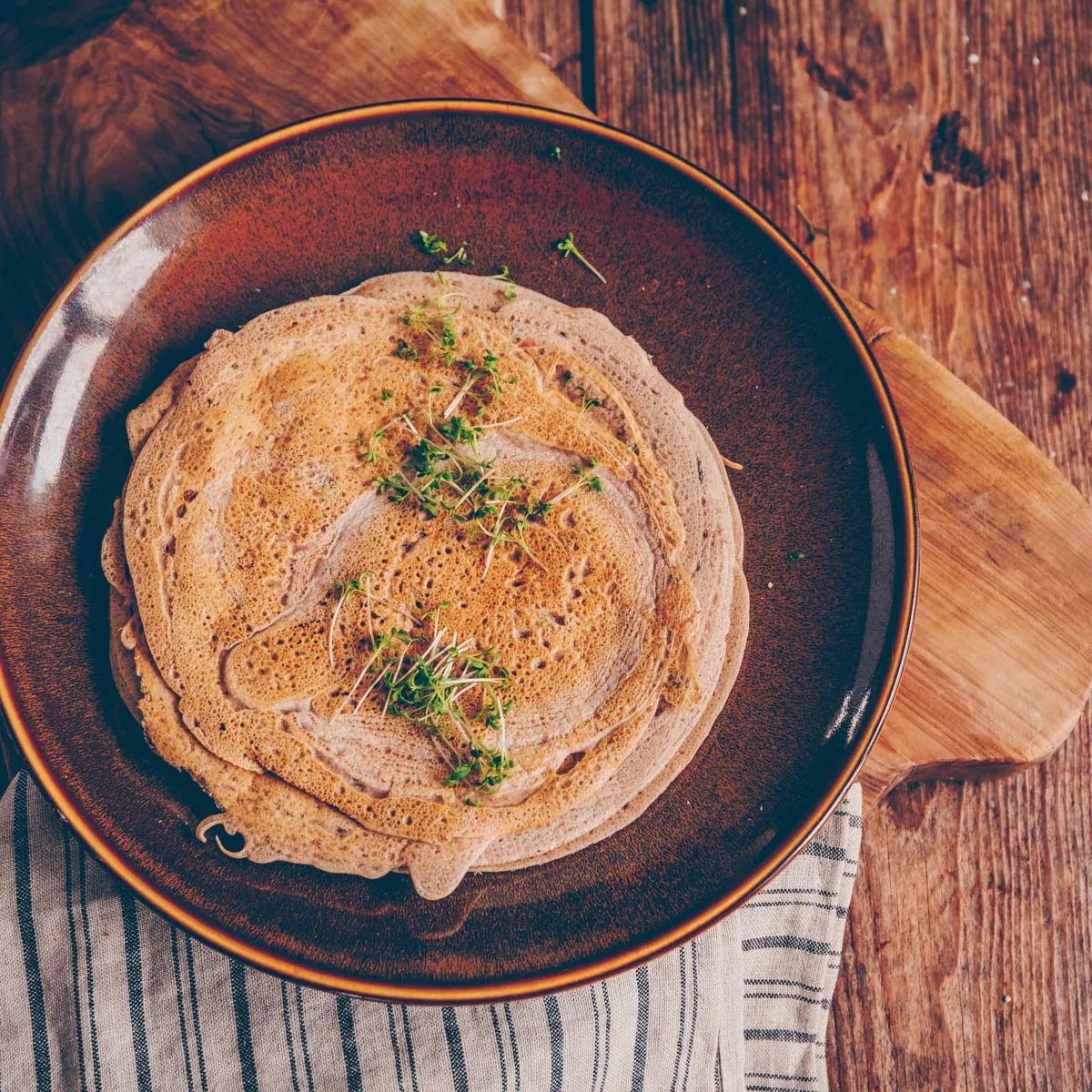 Nahaufnahme von dampfenden Buchweizenpfannkuchen, gefüllt mit einer reichhaltigen und würzigen Spinat-Pilz-Mischung.
