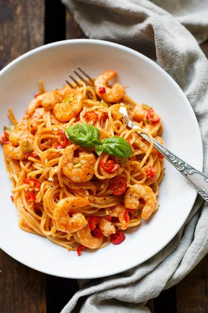 Nahaufnahme von fertig angerichteten Nudeln mit Garnelen und Tomaten-Sahnesauce