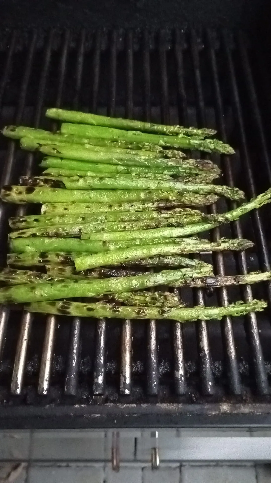 Nahaufnahme von gegrilltem grünen Spargel auf einem Teller